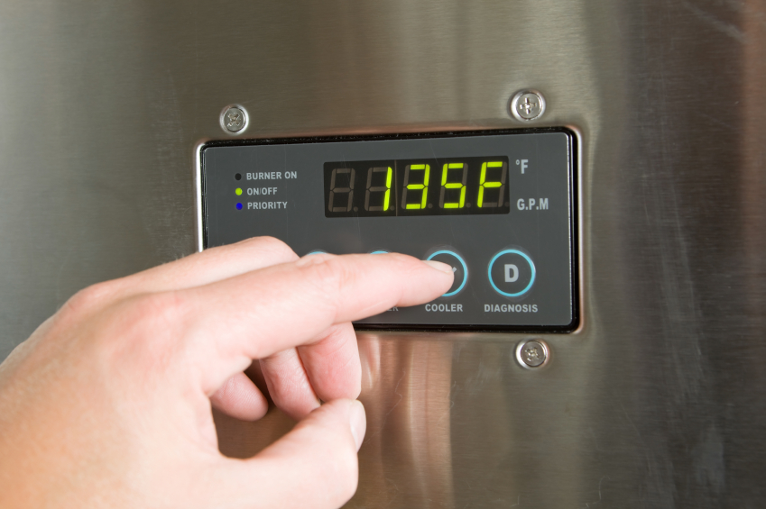 Hand adjusting temperature on a digital control panel, display showing 135°F.