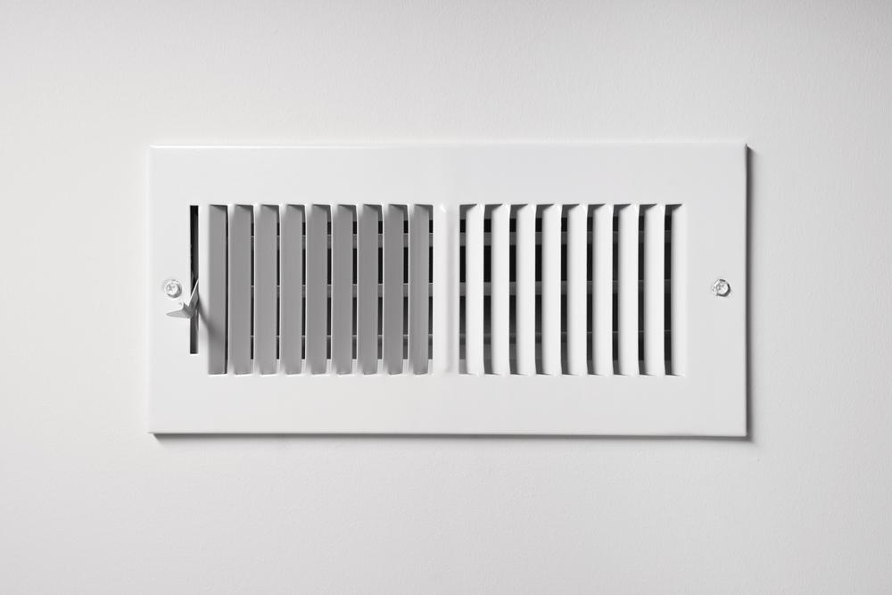  A white wall vent cover with parallel slats divided into adjustable and fixed sections.