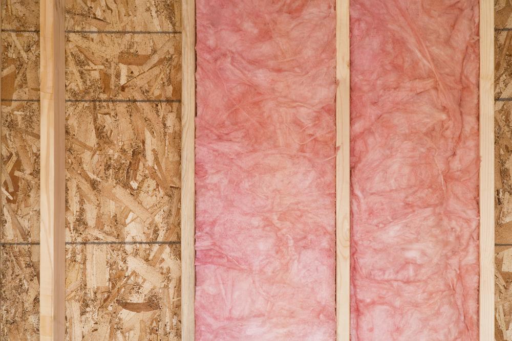 Wall with pink fiberglass insulation on the right, separated by vertical wooden studs.